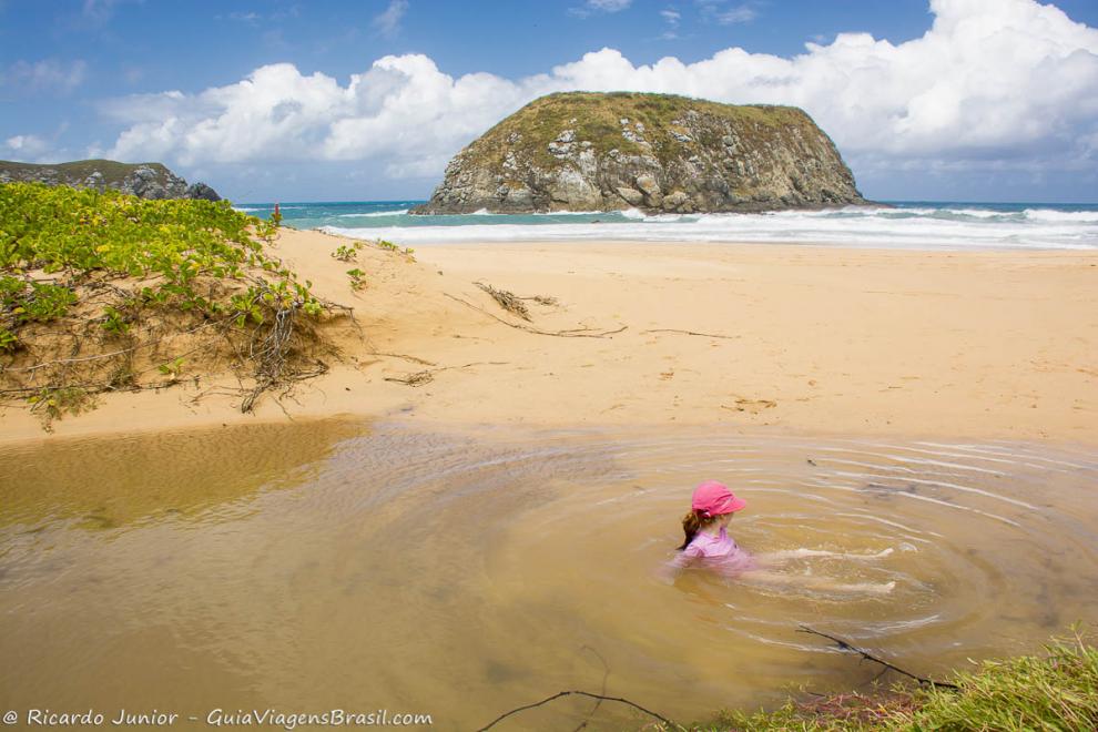 Imagem de uma menina nas piscina natural de Praia do Leão.